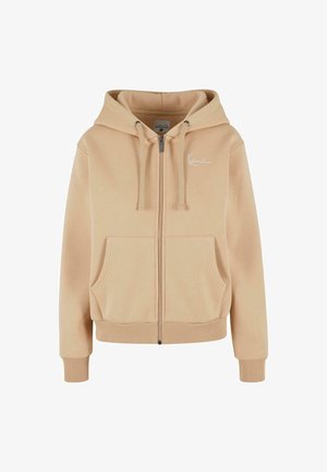Béžová mikina s kapucňou na zips a logom na ľavej hrudi. Obsahuje dve predné vrecká, kapucňu so sťahovacou šnúrkou a rebrované manžety a lem. Mäkká textúra látky.