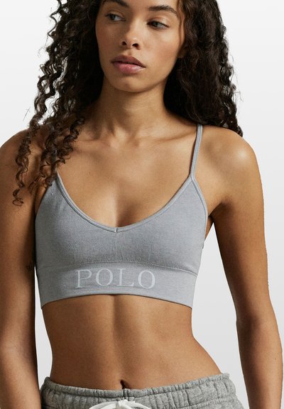Szary bawełniany biustonosz typu bralette z regulowanymi cienkimi ramiączkami, dekoltem w kształcie litery V oraz haftowanym logo "POLO" na elastycznej opasce. Miękka, gładka faktura.