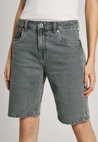 Halli denim lühikesed püksid sirge lõikega, viie taskuga ja eesnupuga sulgmiseks. Kanga pinnal on kerge tekstuur ja need sobivad vabaks kandmiseks.