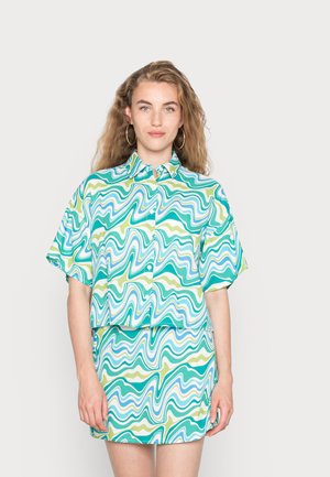 Camisa de manga curta e saia combinando com um padrão ondulado em verde, azul e branco. Feita de um tecido suave com um corte descontraído.