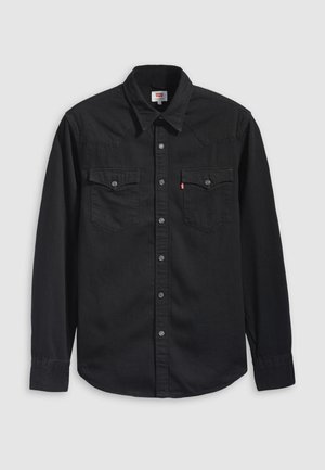 Chemise en denim noir avec col boutonné, deux poches poitrine et un col pointu avec des détails de couture visibles.