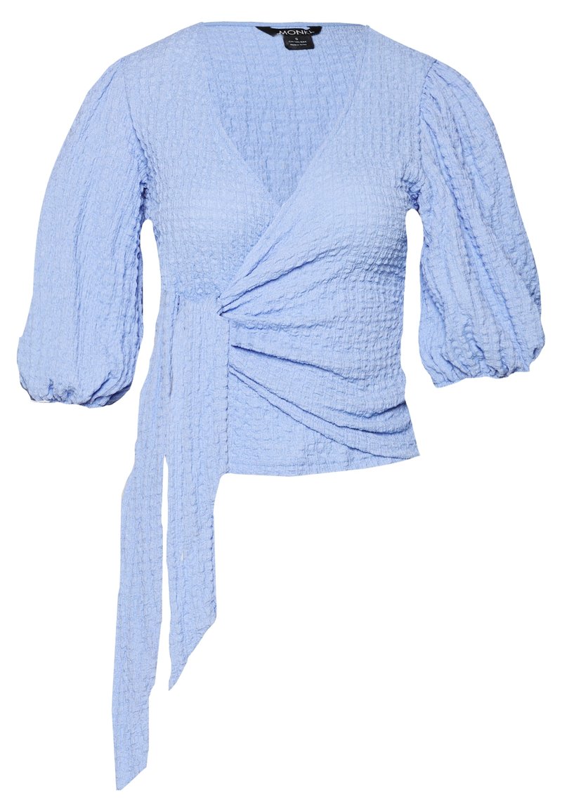 Ljusblå omslagstopp i strukturerad tyg. Har djup V-ringning, puffärmar och en sidoknytning för justerbar passform.