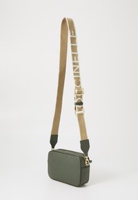 Borsa a tracolla verde in pelle texturizzata con forma rettangolare. Presenta una tracolla beige con logo e accenti in oro.