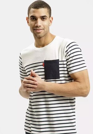 White and navy striped t-shirt featuring a black chest pocket, short sleeves, and a round neckline, made of a soft cotton blend.