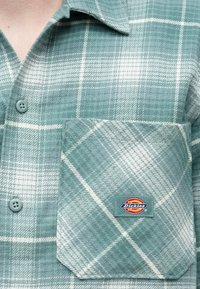 Πράσινο φανελένιο πουκάμισο με καρό μοτίβο και λευκό διαγώνιο σχέδιο, γιακά με κουμπιά και τσέπη στο στήθος μπροστά με τσιμπιδάκι λογότυπου "Dickies".