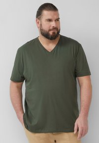 Groen T-shirt met korte mouwen en een V-halsontwerp, gemaakt van soepel materiaal en voorzien van een subtiele logo. Ontspannen pasvorm met een rechte zoom.