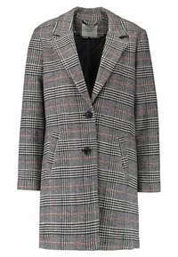 Cappotto a quadri in tonalità di nero, bianco e rosso; presenta un colletto a incavo, tasche frontali, doppi bottoni e una vestibilità ampia. Tessuto strutturato.