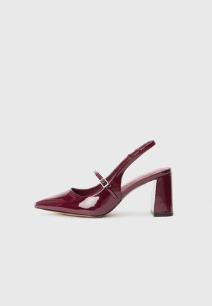 Burgundy patent leather slingback heels with a pointed toe and a medium block heel. Features a buckle strap and a smooth glossy finish.