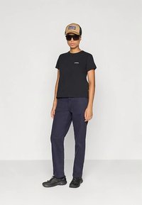 Μαύρο μπλουζάκι με κοντά μανίκια, ναυτικό μπλε παντελόνι, καφέ καπέλο με λογότυπο, γυαλιά ηλίου και μαύρα παπούτσια. Απλός σχεδιασμός με χαλαρή εφαρμογή.