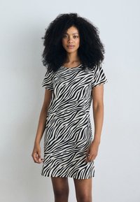 Krátkorychlé šaty s vzorom zebra v čiernej a béžovej farbe, vyrobené z ľahkého materiálu, so priliehavým strihom a okrúhlym výstrihom.