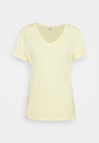 Lichtgeel katoenen T-shirt met V-hals, korte mouwen en een losse pasvorm. Subtiele stikseldetails nabij de zoom. Geen patronen of accenten.