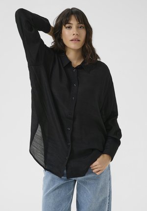 Black button-up shirt made of lightweight fabric, featuring a pointed collar, long sleeves, and a loose fit with side slits.