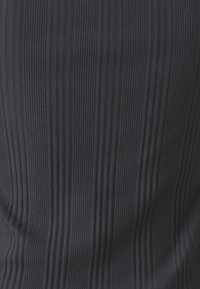 Svart ribbet tekstur med vertikale striper, som viser en glatt overflate med lett elastisk strekk.