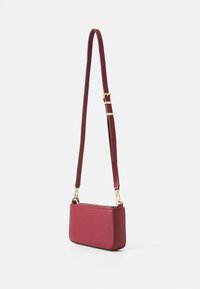 Borsa a tracolla rossa in pelle con finitura testurizzata. Presenta una forma sottile, hardware dorato e una tracolla regolabile.