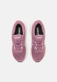 Baskets de course en mesh violet avec des accents blancs, languette rembourrée et lacets, présentant un dessus texturé et une semelle rembourrée pour le confort.