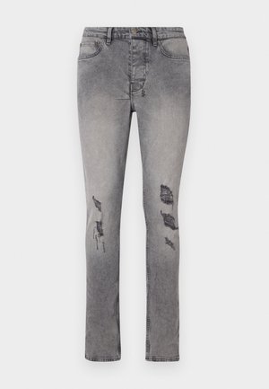 Jeans de denim cinza com um corte slim e ligeira elasticidade. Apresentam remendos desgastados nos joelhos e um design clássico de cinco bolsos.