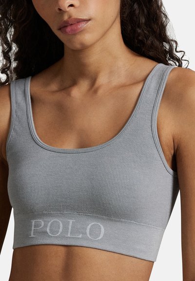 Grå ribbad kort topp med breda axelband och rundad halsringning. Har ett elastiskt band med märkeslogotyp i botten med "POLO" broderat i vitt.