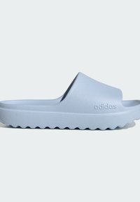 Hellblaue Adidas Slide-Sandale mit strukturierter Sohle und erhabenem Logo auf breitem Riemen, seitlich auf einfarbigem Hintergrund gezeigt.