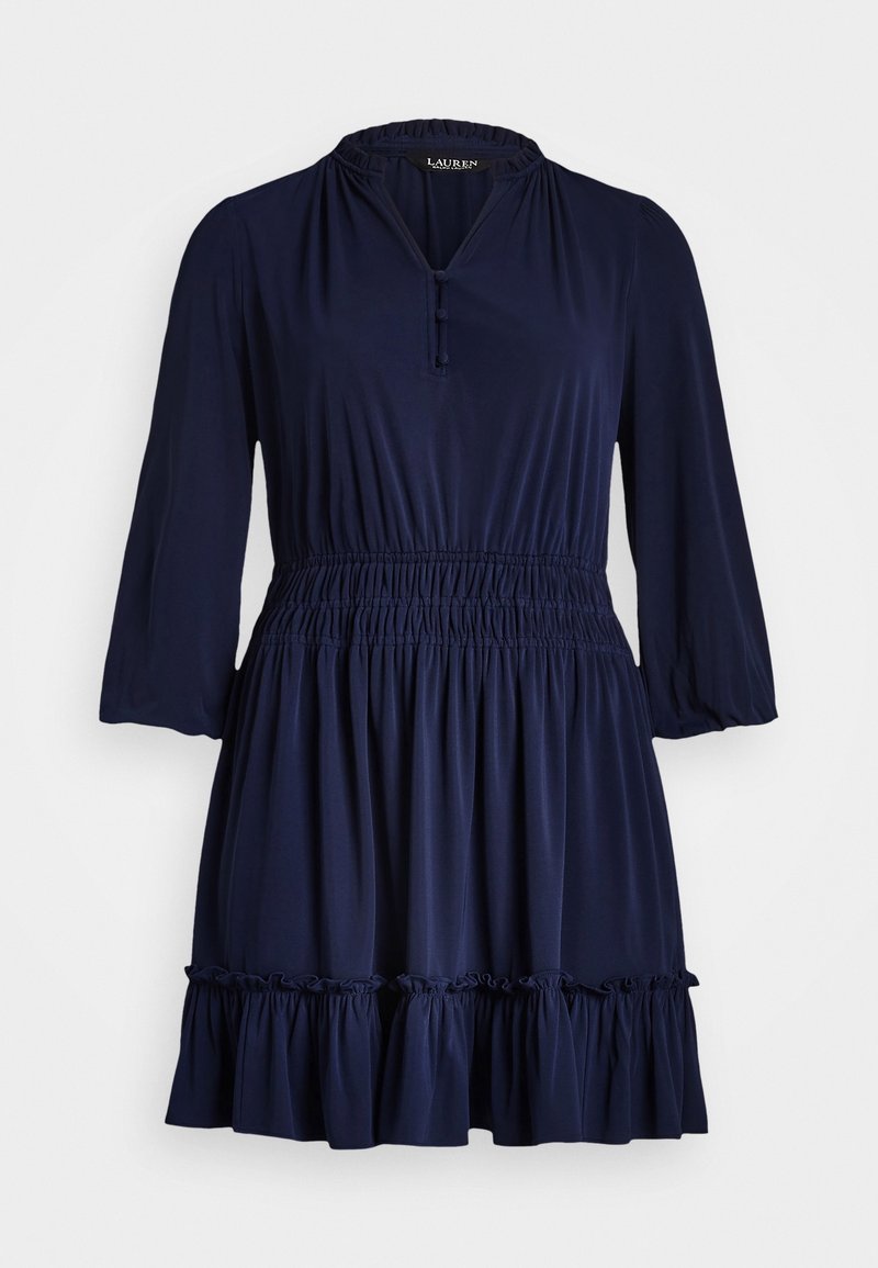 Granatowa sukienka z dekoltem w serek, marszczonym pasem, luźnymi rękawami i falbaną u dołu. Wykonana z miękkiego materiału, zaprojektowana z myślą o komforcie i wygodzie.