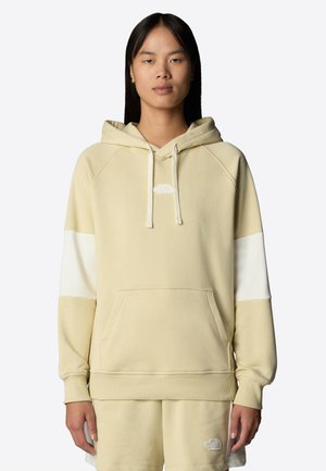 Crème-kleurige hoodie met een kangoeroezak, raglanmouwen en een witte accent op de mouw. Bevat een klein logo op de borst.