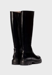 Botas de cuero negras hasta la rodilla con punta redondeada, acabado texturizado y suela de tracción. Presentan una lengüeta en la parte superior y un logo en relieve en el talón.