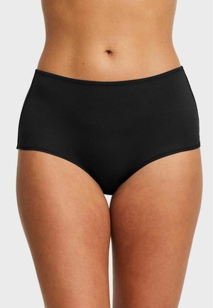 Vrouwelijke torso met hooggesneden zwarte katoenen slipjes, afgebeeld van de taille tot de bovenbenen tegen een effen achtergrond.