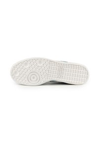 Suola di scarpa in gomma bianca con motivo di texture antiscivolo e accenti circolari. Presenta una parte superiore di colore azzurro chiaro lungo il bordo.