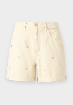 Crèmekleurige denimshorts met opgerolde pijpen en kleine geborduurde hartpatronen verspreid over de stof.