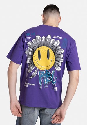 Purple cotton t-shirt featuring a large yellow smiley face with a flower design on the back. Includes graphic text and various colors.