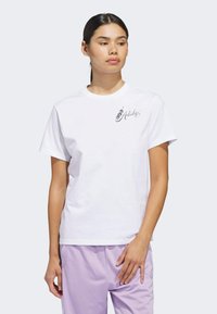 Bílé bavlněné tričko s krátkými rukávy a kulatým výstřihem, na levé straně hrudi černé logo. Hladká textura, volný střih.