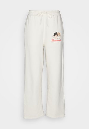 Pantaloni de trening de culoare crem, cu o croială lejeră, talie cu șnur și un grafic brodat cu două figuri și textul "Fruity."