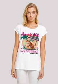 White cotton t-shirt featuring a colorful graphic of a tiger, palm trees, and text reading "Beverly Hills California Glamour & Sunshine."