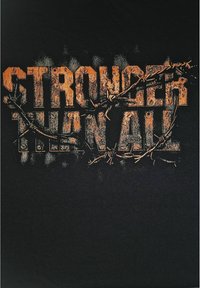 Sort t-shirt med teksten "STÆRKERE END ALLE" i slidt orange skrift, snoet med tornebeskyttelse som accent.