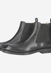 Schwarze Leder-Stiefeletten mit elastischen Seitenteilen, abgerundetem Zehenbereich und Zuglaschen. Glatte Textur mit flacher Gummisohle.