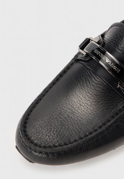 Must musta loafer sileda tekstuuriga, millel on hõbedane sõlg ja diskreetne õmblusdetail.