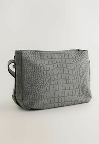 Grå crossover taske med en struktureret kunstlæderoverflade i krokodilleskindsdesign, rektangulær form og klaplukning.