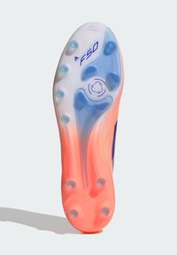 Suela de zapatilla de fútbol con un degradado de rosa a translúcido, seis tacos azules, cinco tacos transparentes y "F50" impreso cerca de la zona del dedo del pie.