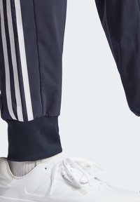 adidas Sportswear ESSENTIALS 3-STRIPES - Tracksuit bottoms - legend ink white