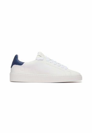 Sneaker basse in pelle bianca con un tab sul tallone blu navy, lacci bianchi piatti e una texture liscia. Suola in gomma bianca spessa. Design minimalista.