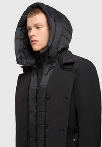 Czarna kurtka puchowa z dużym, przymocowanym kapturem, pikowanym wzorem, podwójnym zapięciem z przodu i zamkiem błyskawicznym.