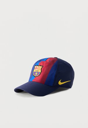 Casquette bleu marine avec des rayures verticales rouges et bleues, présentant le blason du FC Barcelone au centre devant et un swoosh Nike jaune sur le côté.