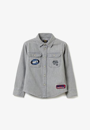 Lichtgrijs denim overhemd met lange mouwen, drukknopen, twee borstzakken met motorfiets-thema patches en een kraag.