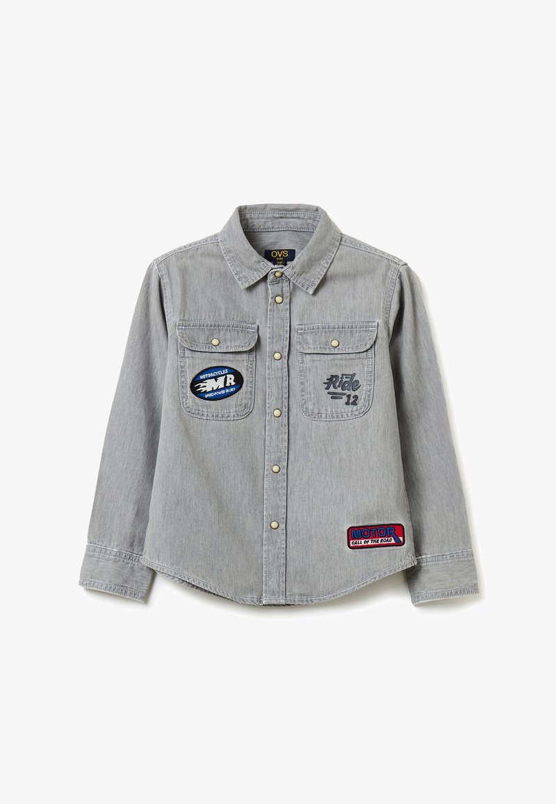 Chemise en denim à manches longues gris clair avec boutons-pression, deux poches poitrine ornées de patchs à thème moto et un col.