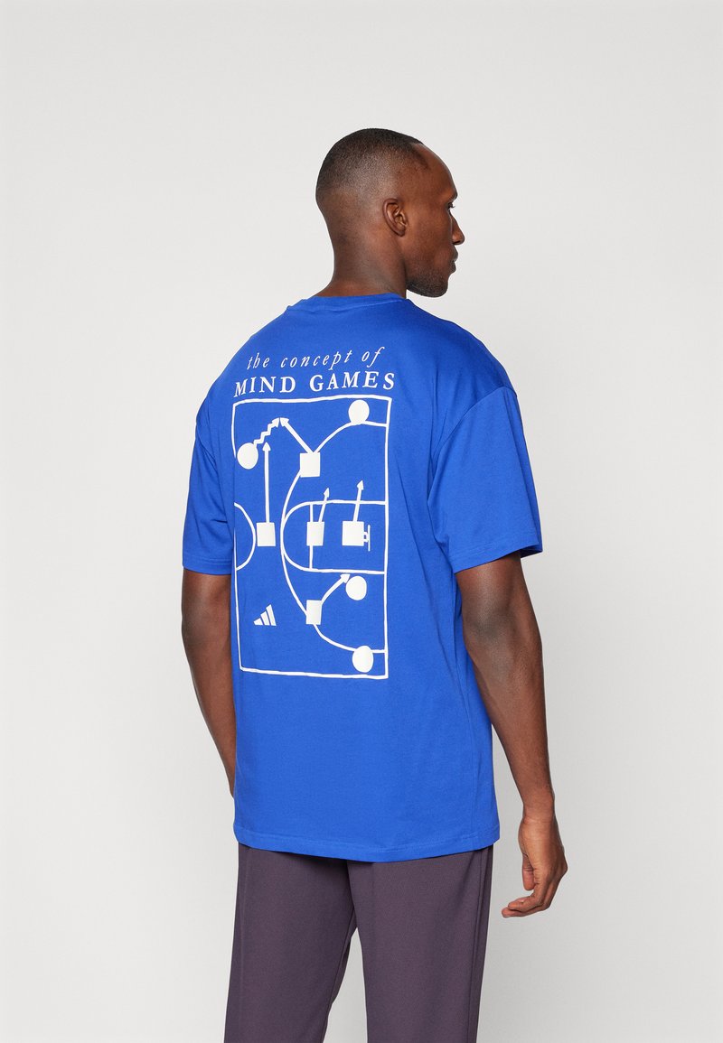 Blue cotton t-shirt featuring a white graphic design of geometric shapes and text on the back, short sleeves, and a relaxed fit.