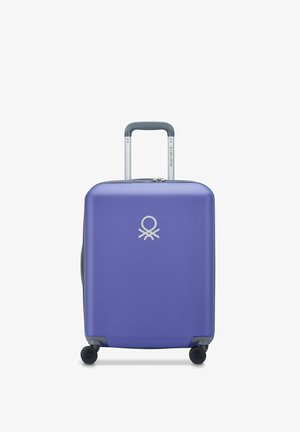Valigia rigida viola con finitura liscia, logo argentato sul davanti, manico grigio retrattile e quattro ruote nere per la mobilità.