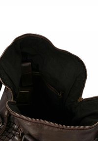 Sac à main en cuir marron avec fermeture éclair, présentant une texture tissée d'un côté et un intérieur en tissu noir. Équipé de quincaillerie en métal.