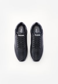 Zwarte leren sneakers met geperforeerde accenten, ronde neus, platte veters, witte logo-detail op de tong en een gevoerde zool.
