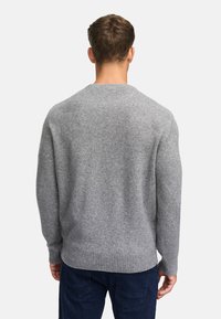 Grijs gebreid sweater met een ronde hals, geribbelde manchetten en onderrand, met een zachte textuur en een ontspannen pasvorm, gecombineerd met donkerblauwe broek.