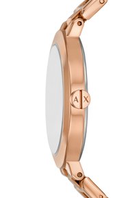 Roséguld metallklocka med en slät rund boett, glasfront och silverdetaljer. Har dubbla tryckknappar märkta med "A" och "X."