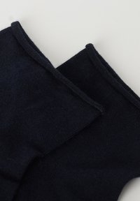 Calcetines azul marino oscuro hechos de un tejido suave. Presentan una textura acanalada y bordes cosidos, con un diseño simple y minimalista.
